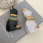 Black and white glitter Egyptian cat hair clips on a book