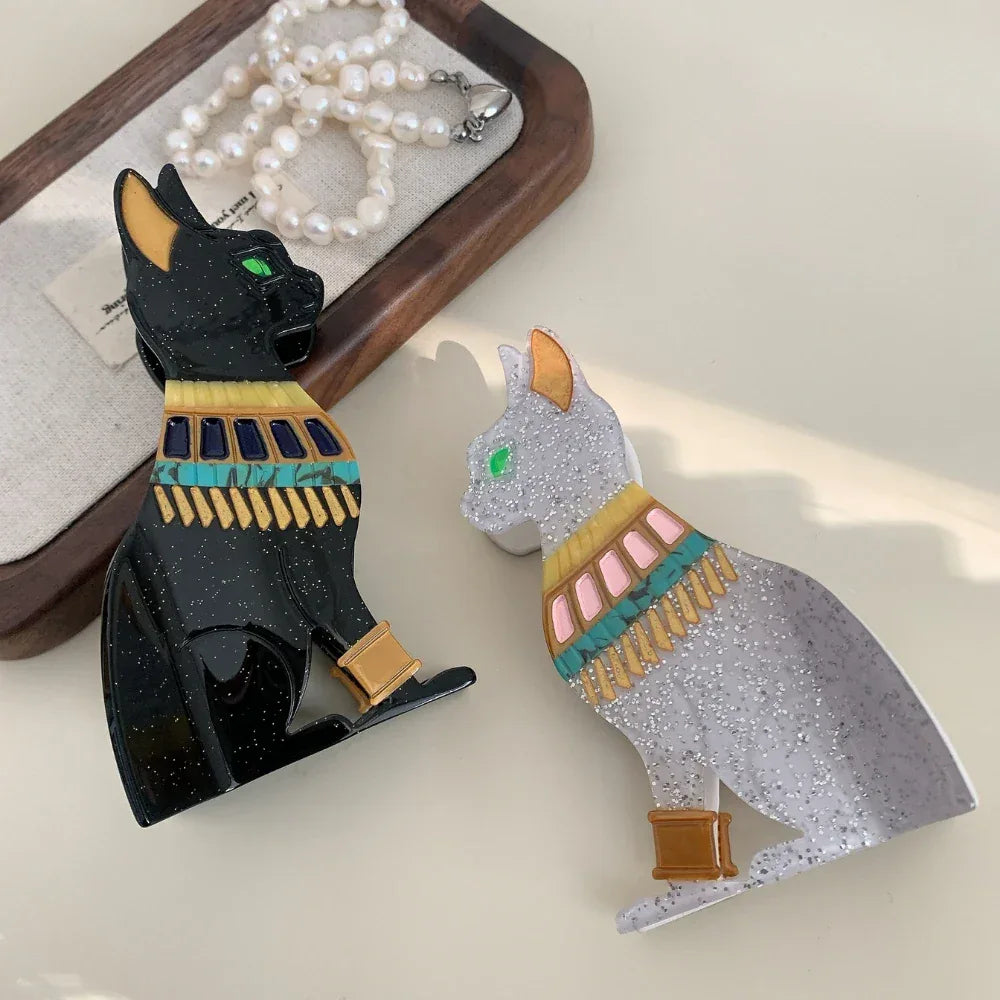 Two glitter Egyptian cat hair clips facing each other