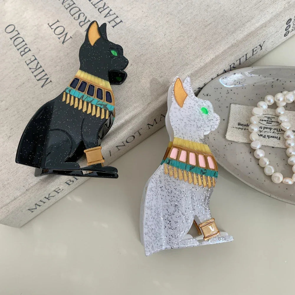 Black and white glitter Egyptian cat hair clips on a book with pearls
