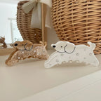 Two dog-shaped hair claw clips, one white and one brown, with sparkling embellishments, displayed on a white shelf
