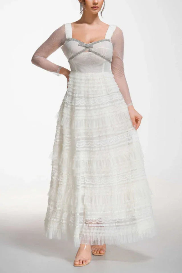 Model posing in a white tiered tulle gown with crystal embellishments