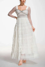 Model posing in a white tiered tulle gown with crystal embellishments