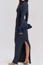 Back view of a navy blue long-sleeved column gown with ruffled cuffs.