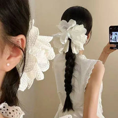 close-up of a woman's ear with a white lace hair accessory in her hair