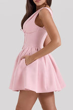 Pink sleeveless V-neck dress with a fitted bodice and flared skirt, side view showing pocket detail