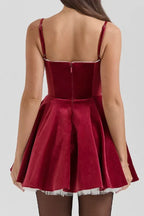 Rear view of a red velvet dress with a full skirt and lace hem.
