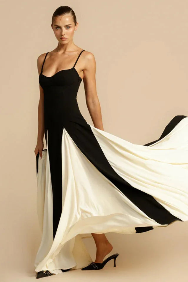 Woman with a black and white gown, lifting the skirt to reveal the flowing fabric.