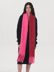 Front view of a woman wearing a black sweater and a two-toned pink and red scarf.