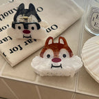 Close-up of two cartoon chipmunk face hair claw clips on a fabric bag