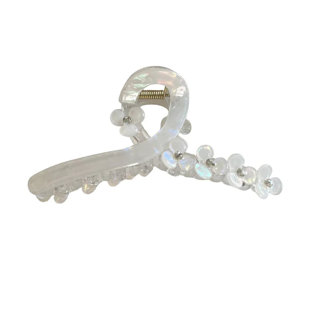 A clear and iridescent claw hair clip adorned with small white flowers and sparkling accents. Main image
