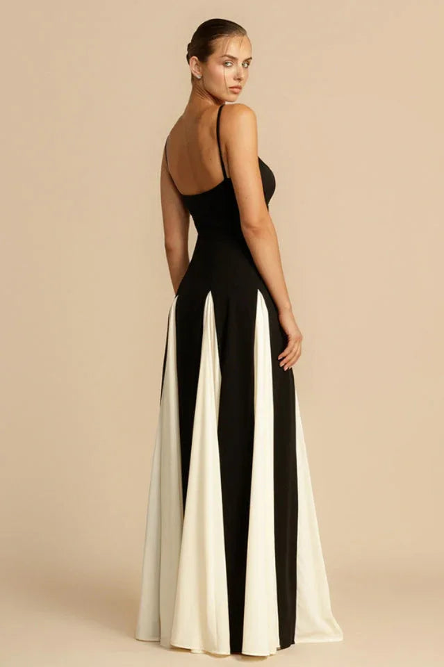 Back view of a woman in a black and white floor-length gown with a fitted bodice and paneled skirt.