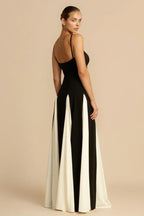 Back view of a woman in a black and white floor-length gown with a fitted bodice and paneled skirt.