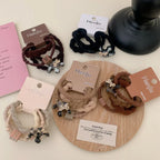 Collection of Henju hair bands in various neutral colors with decorative charms