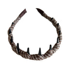A brown and white plaid fabric-wrapped headband with black interlocking teeth