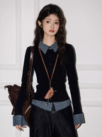 Full-body shot of a model in a layered black top with checkered accents, dark wash wide-leg jeans, and a brown shoulder bag.
