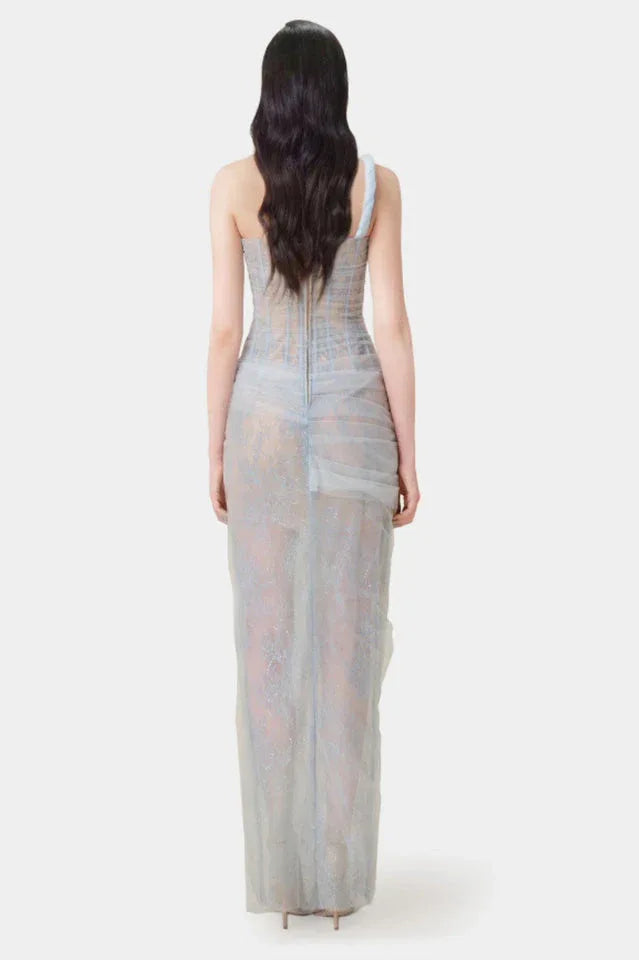 Model wearing a beige sheer tulle gown with a one-shoulder design and corset bodice.