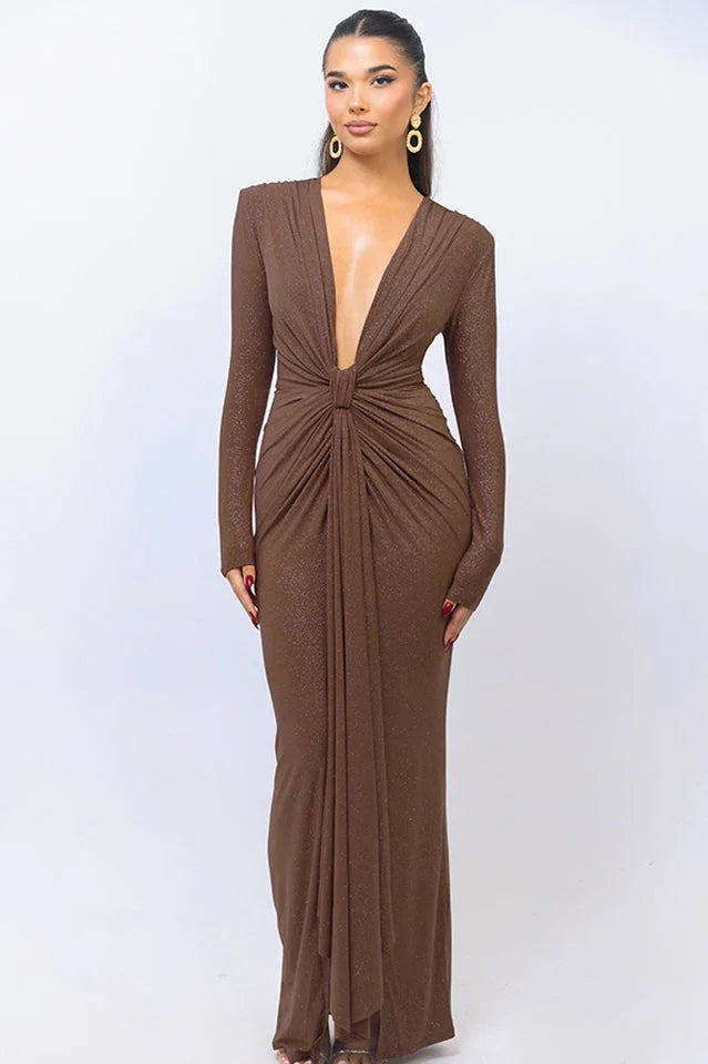 Woman wearing a long-sleeved, deep V-neck, floor-length brown sparkly dress, front view