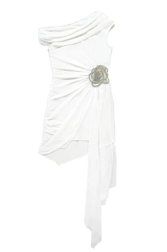 Flat lay of white one-shoulder asymmetrical hem dress with draped detail and rose embellishment