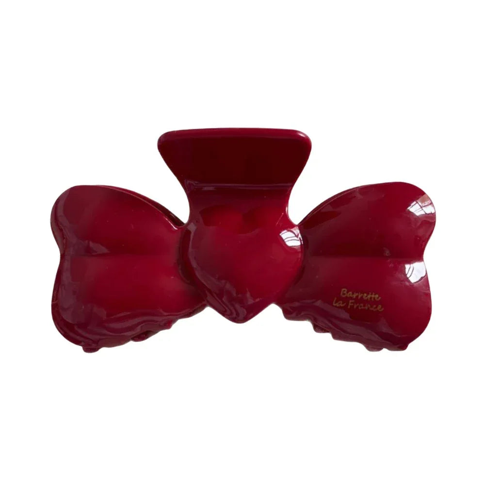 Red bow-shaped hair clip with a glossy finish. Main image