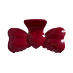Red bow-shaped hair clip with a glossy finish.