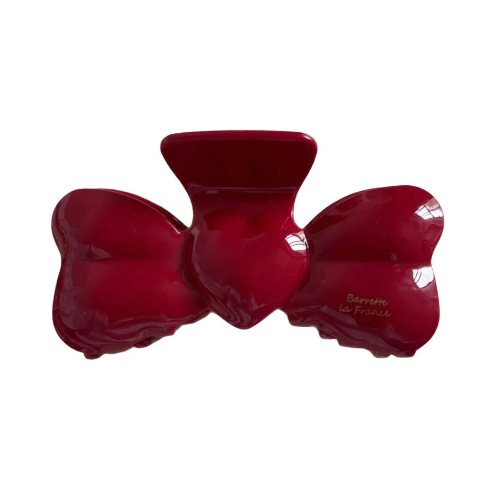 Red bow-shaped hair clip with a glossy finish. Main image