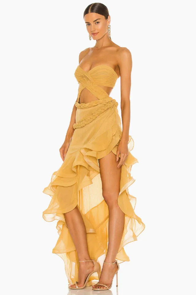 profile view of a woman wearing a flowing yellow gown with ruffled layers