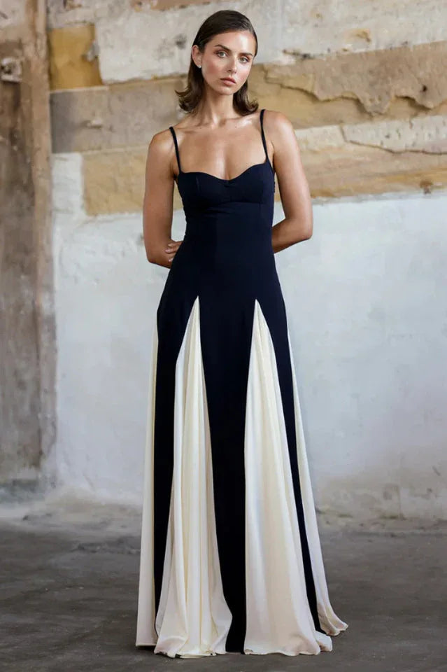 Woman wearing a black and white floor-length gown with spaghetti straps and a sweetheart neckline. Main image