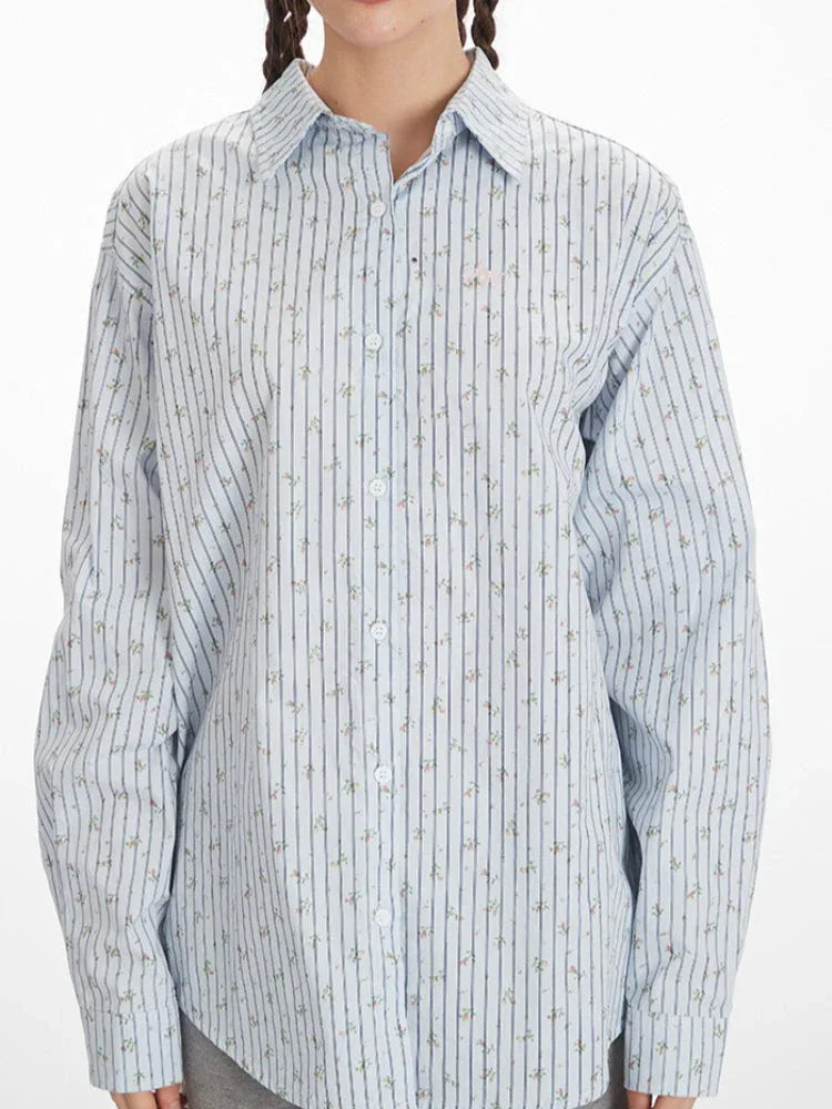 Close-up front view of the light blue pinstripe button-down shirt with floral accents.
