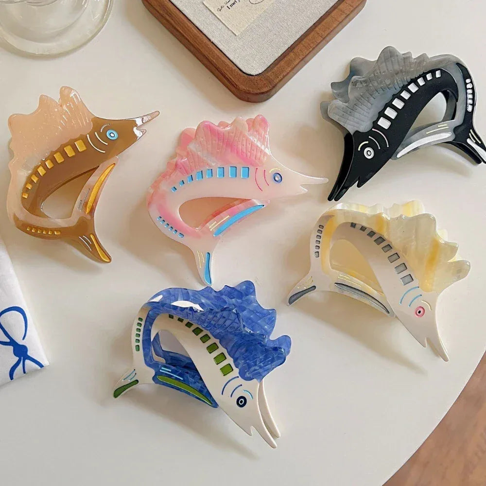 Group of five marlin-shaped hair clips displayed on a white table