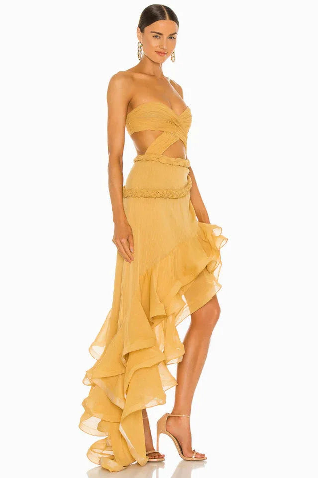 woman posing in a yellow strapless dress with a ruffled hem and cut-out detail