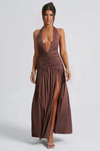woman wearing a brown halter maxi dress with a deep v-neckline and high slit