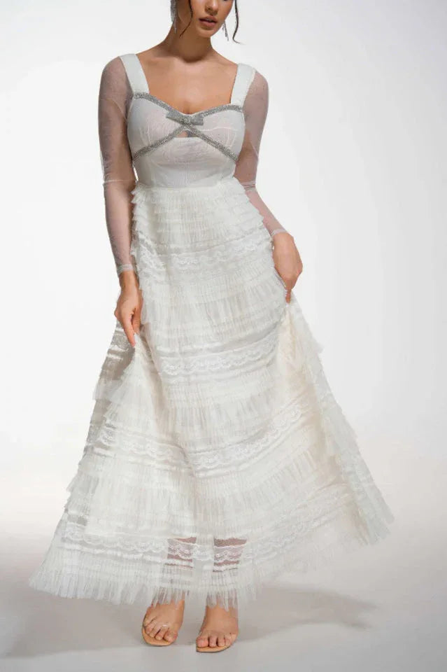 Woman wearing a white tiered tulle gown with long sheer sleeves Main image