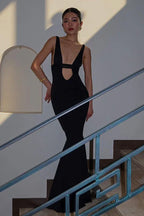 woman in a sleek black dress with a halter neckline and a dramatic skirt