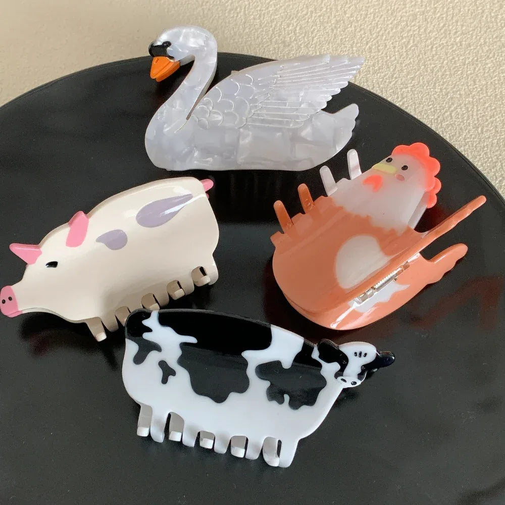 Set of four animal-shaped hair clips including a pig, chicken, cow, and swan