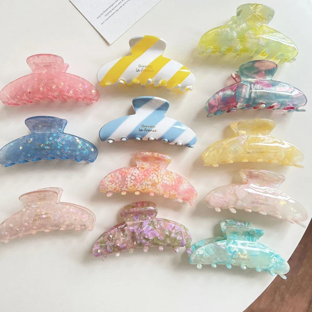Variety of glitter, striped, and marble patterned hair claw clips displayed