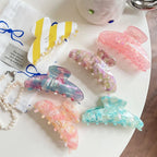 Assortment of pastel and marble patterned hair claw clips on a white surface