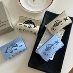 Collection of four hair claw clips with ocean-themed designs, including dolphins and seashells, in blue and cream colors