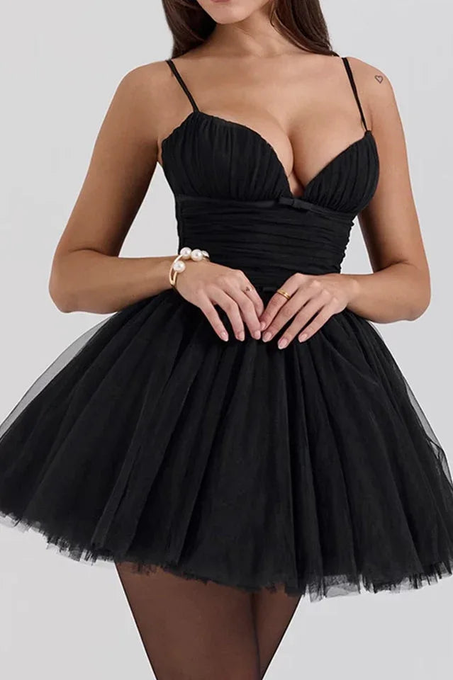woman in black mini dress with ruched bodice and tulle skirt, wearing jewelry