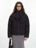 Close-up of the model's upper body, showcasing the black puffer jacket with its integrated scarf detail.