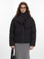Close-up of the model's upper body, showcasing the black puffer jacket with its integrated scarf detail.