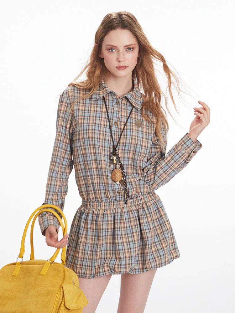 Close-up of model wearing a plaid shirt dress and holding a yellow handbag
