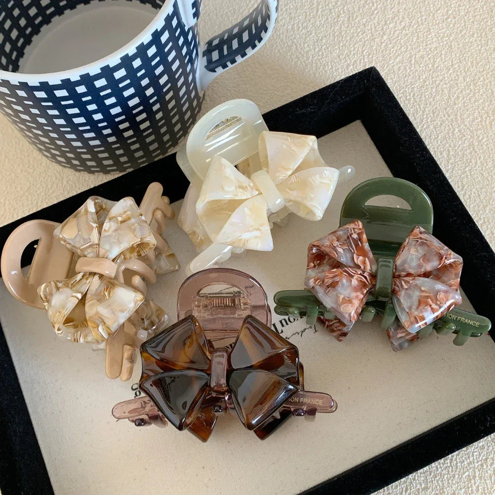 Collection of bow claw clips in various colors and marbled patterns