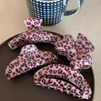 collection of pink leopard print hair claw clips on a black plate
