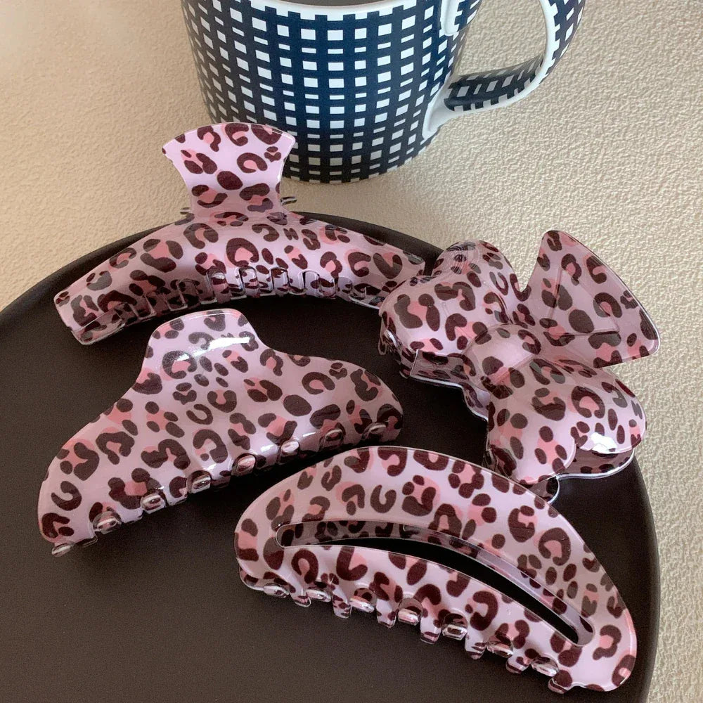 collection of pink leopard print hair claw clips on a black plate