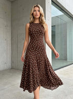 Woman wearing a brown polka dot midi dress in an outdoor setting