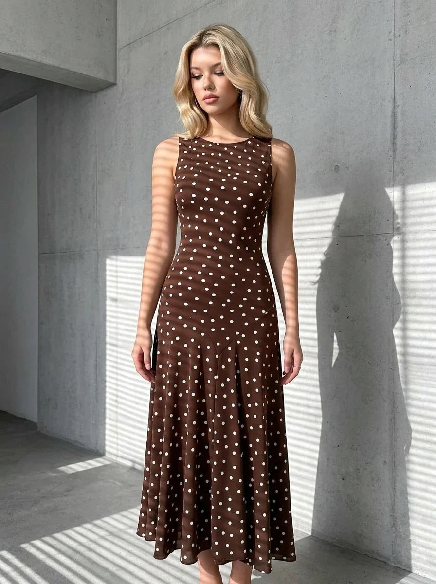 Woman wearing a brown polka dot midi dress in an urban setting