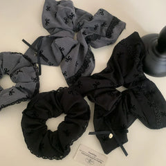 various scrunchies in black and grey with bow patterns and lace trim laid out