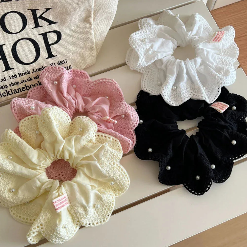 Collection of scrunchies in white, pink, yellow, and black with lace and pearl details