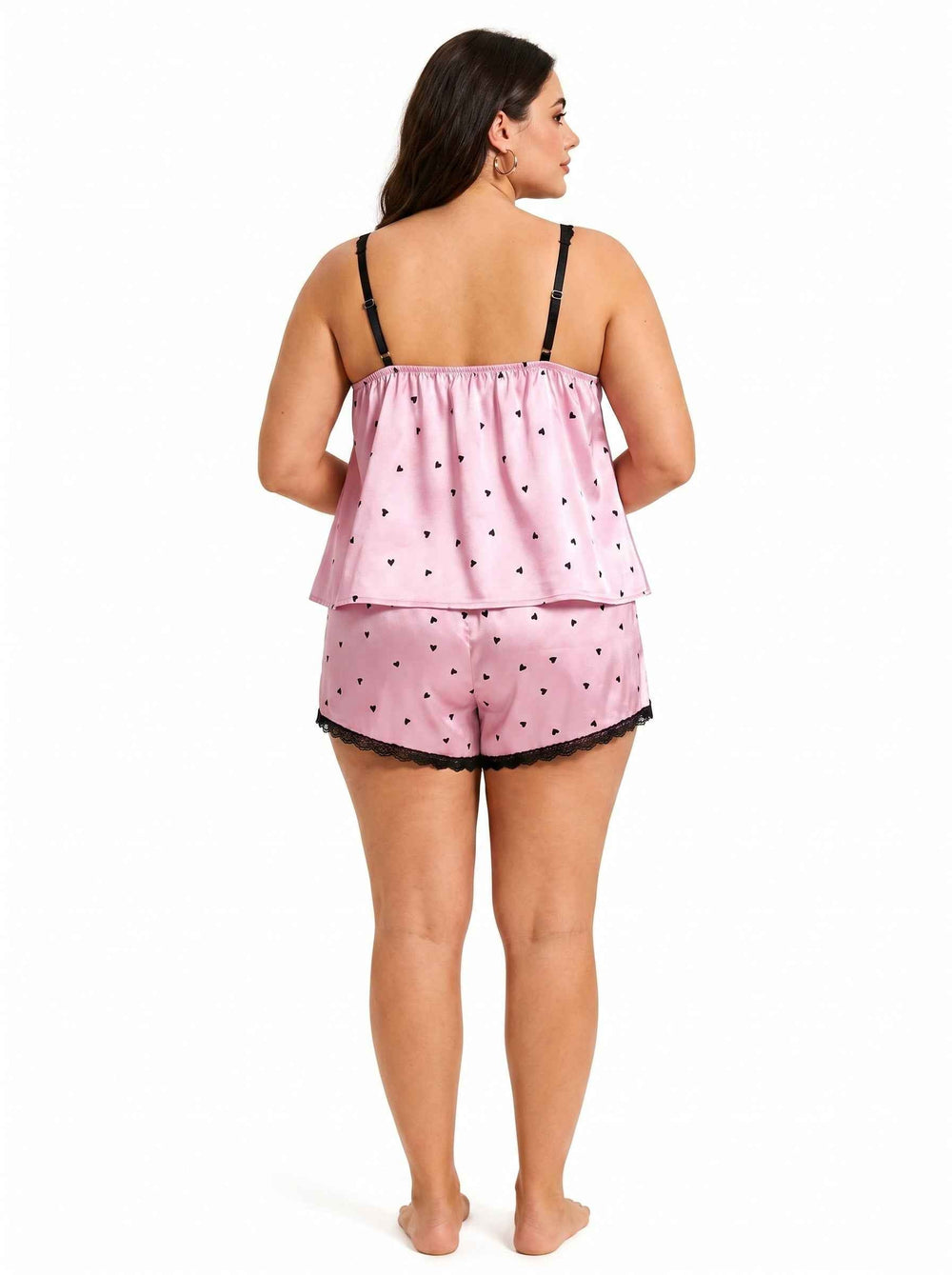 Back view of a pink satin cami and shorts pajama set with black heart print and lace trim.