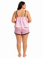 Back view of a pink satin cami and shorts pajama set with black heart print and lace trim.